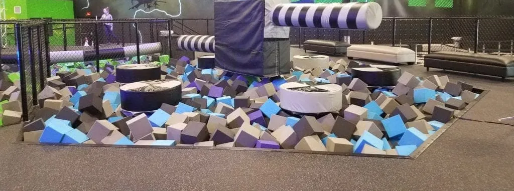 deep foam block pit with padded rolling logs and a soft landing platform under the airbag high dive